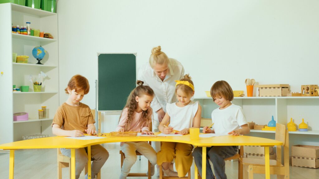 pexels-photo-8087923-8087923 A teacher guides young students in a bright classroom setting.