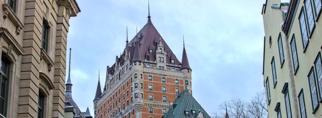 View of Château Frontenac surrounded by historic buildings in snowy Québec City, Canada.